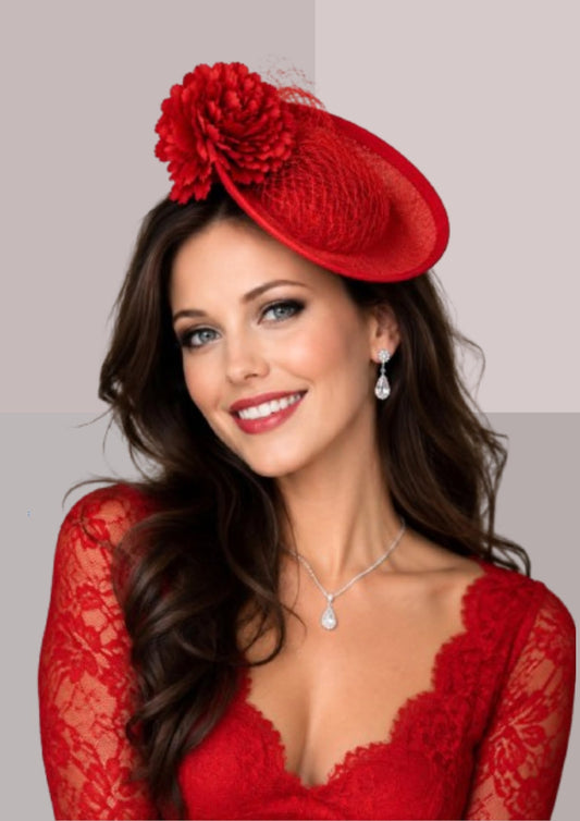 Bibi rouge porté de face, création artisanale en plateau léger, fleur textile et voile décoratif. Un accessoire de cérémonie élégant pour mariage, cocktail ou réception | Cap-Chapeau