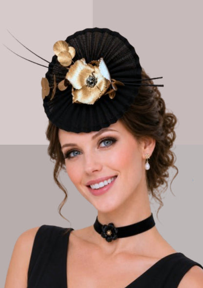 Grand bibi de cérémonie noir plissé orné d'une fleur dorée et branches végétales, accessoire de cheveux chic pour réception | Cap-Chapeau