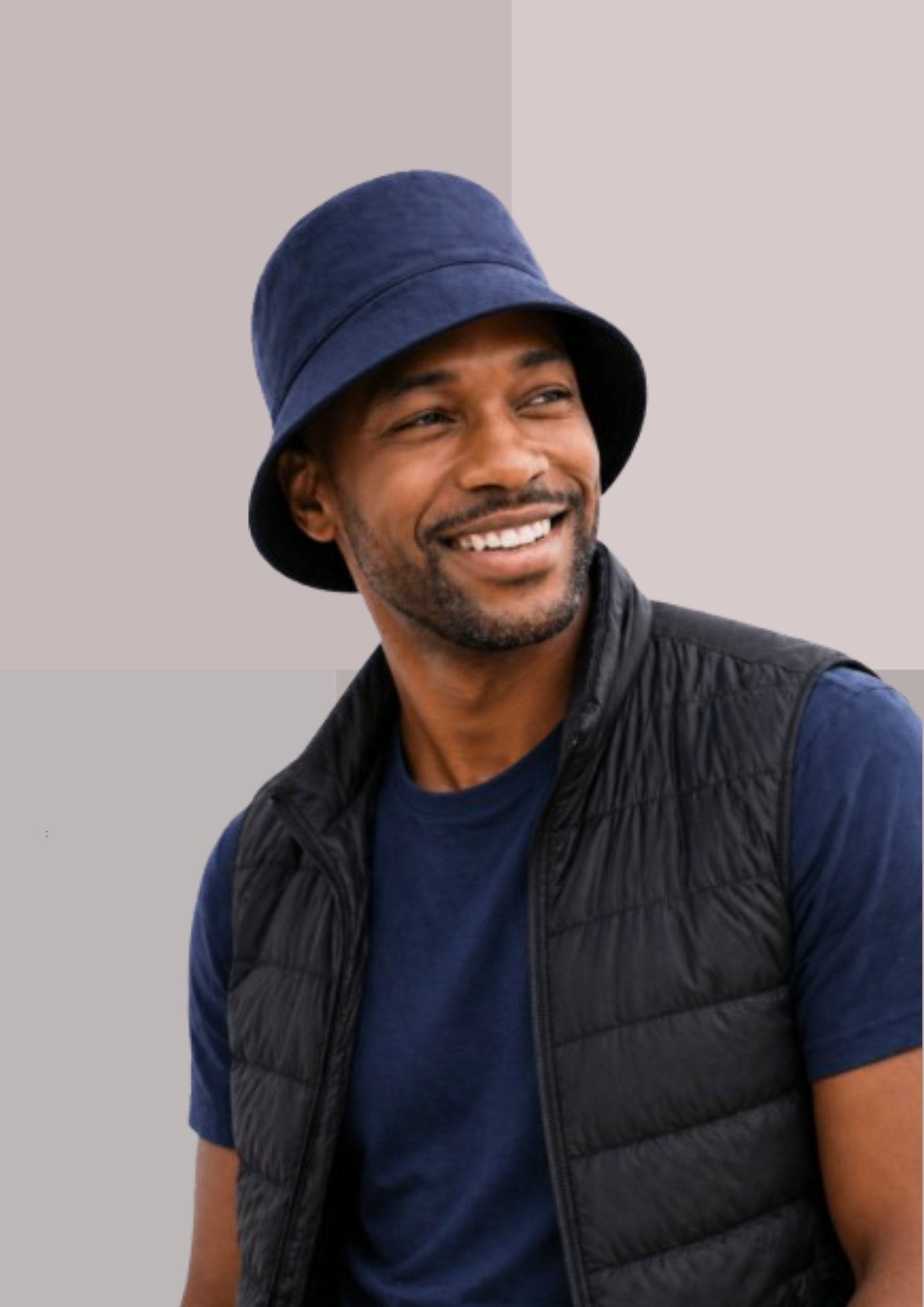 homme noir charmant avec chapeau bob marine, Tshirt marine et gilet doudoune noir| Cap-Chapeau