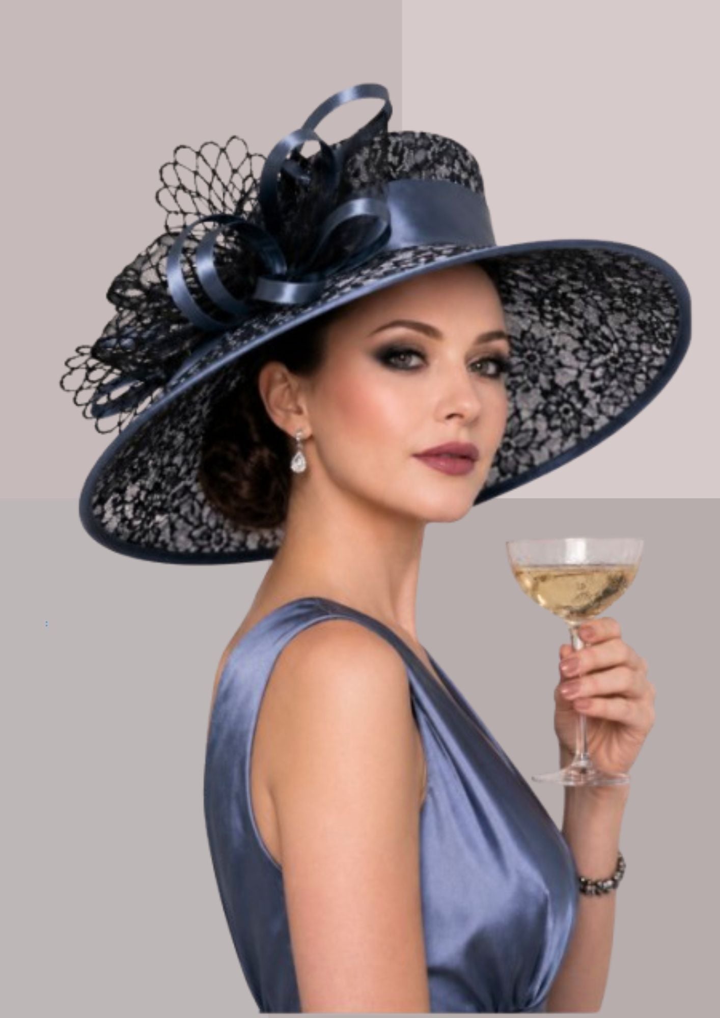 Femme très élégante, de dos, en robe du soir en satin gris sombre et coiffée d'une capeline de réception ajourée même couleur, avec nœud et buvant une coupe de champagne | Cap-Chapeau